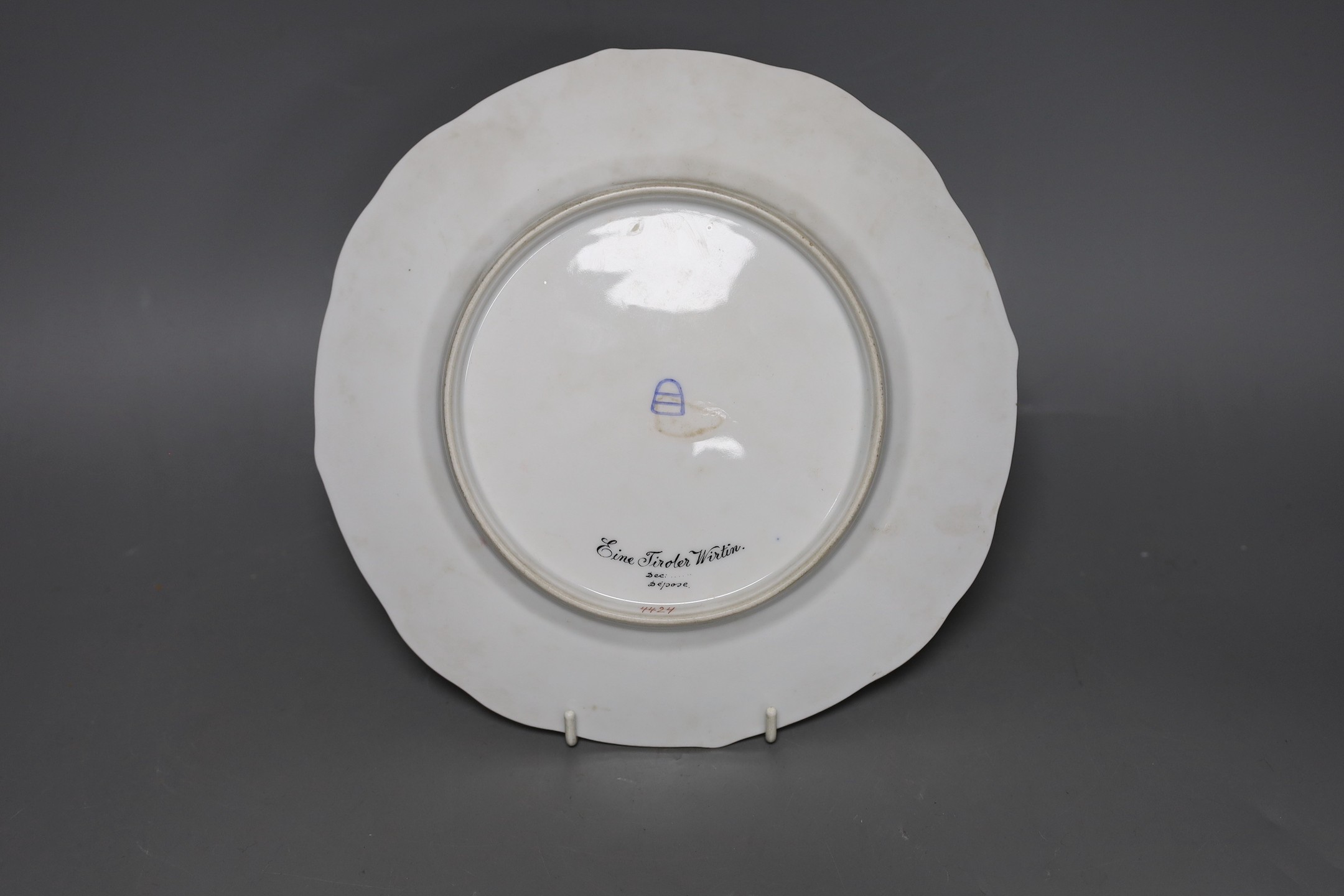 A late 19th century Vienna style painted portrait dish, titled Einer Tiroler Wirtin, 24.5cm